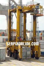 ID 155 PORTS OF AUCKLAND, NZ - Straddle carrier uplifts a 20' container during operations on Ports of Aucklands' Axis Fergusson Container Terminal.